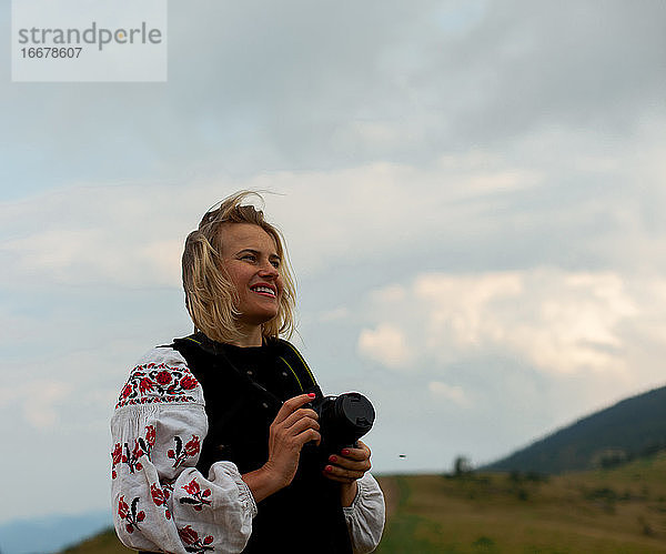 Fotografin im Sommer hoch in den Bergen in der ukrainischen Stickerei