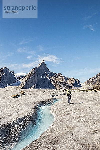 Dramatischer Blick auf einen Bergsteiger  der sich dem Berg Loki  Baffin Island  Kanada  nähert.