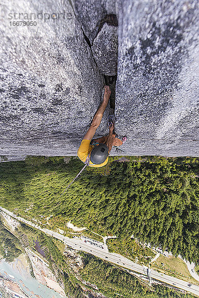 Mann klettert im Vorstieg einen breiten Riss hoch über dem Boden in Squamish