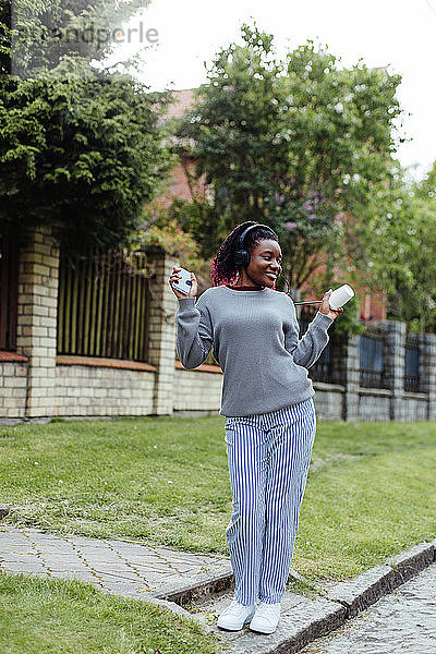 Afroamerikanische Frau tanzt und hört Musik auf der Straße
