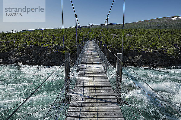 Hängebrücke über das fließende Wasser des Flusses Vuojatädno entlang des Padjelantaleden-Pfades  Lappland  Schweden