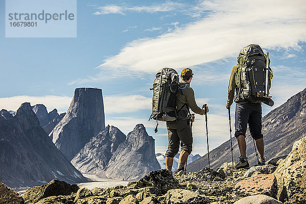 Zwei Rucksacktouristen betrachten die Aussicht von einem Bergkamm aus.