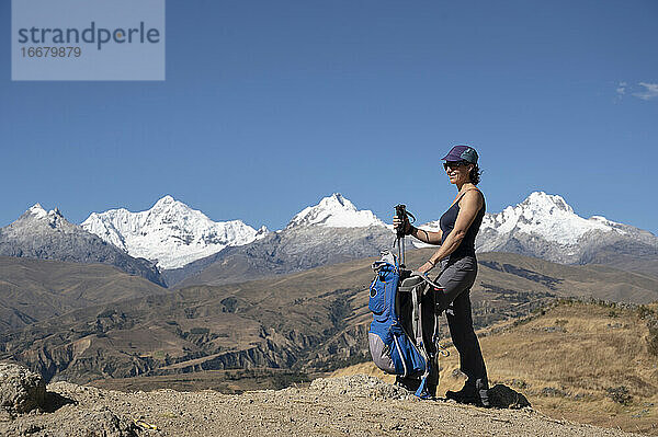 Eine Frau macht eine Pause beim Wandern in der Cordillera Blanca