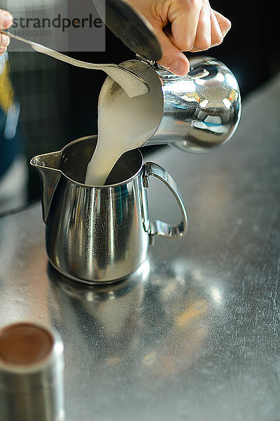 Hände einer jungen erwachsenen kaukasischen Barista-Frau bei der Arbeit