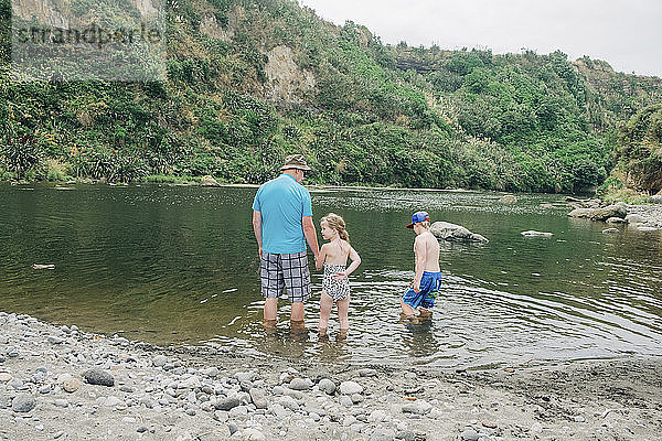Familie beim Spielen im Wasser an einem malerischen Flussabschnitt