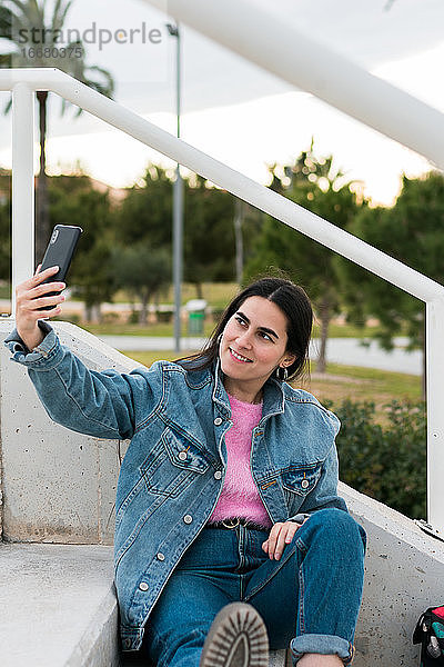 Junge Frau macht ein Selfie auf einem Universitätscampus