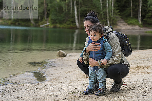 Mutter mit kleinem Jungen schaut beim Wandern am Seeufer weg.