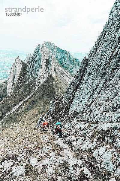 Zwei junge Bergsteigerinnen besteigen eine steile Bergwand in der Schweiz