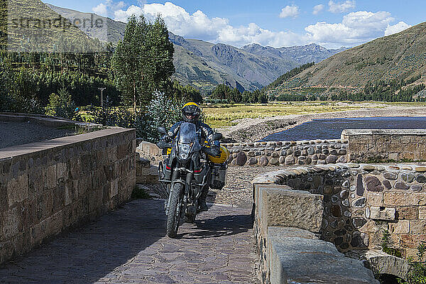 Motorradfahrt über eine Brücke des Urubamba-Flusses  Peru