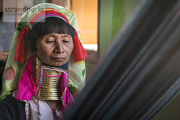 Porträt einer älteren birmanischen Frau vom Stamm der Kayan beim Weben in einer Textilwerkstatt  Inle-See  Myanmar