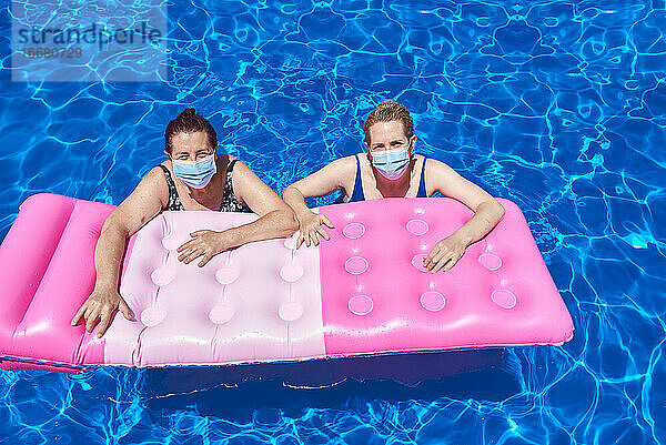 Zwei Frauen baden in einem Pool mit einer Maske.