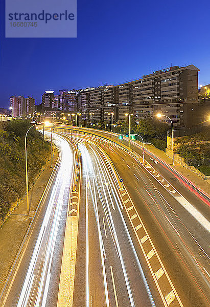 Langzeitbelichtung in der Abenddämmerung in einer Straße mit viel Verkehr in Alicante.