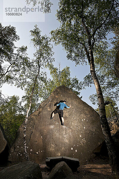 Reife Frau beim Bouldern im Wald von Fontainebleau in der Nähe von Paris