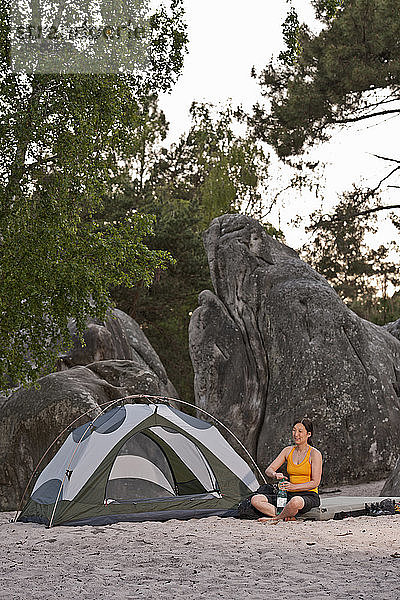 Reife Frau beim Zelten im Wald von Fontainebleau in der Nähe von Paris