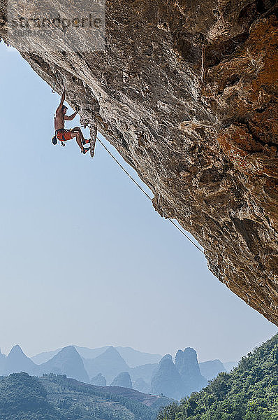 Mann beim Klettern in Odin's Den in Yangshuo  einem Klettermekka in China