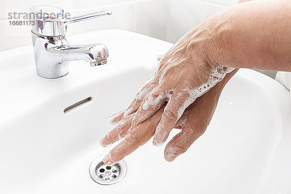 Frau wäscht sich die Hände und desinfiziert sie für die Coronavirus-Krankheit