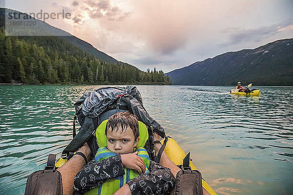 Junge mit mürrischem Gesicht auf einem See während einer Paddeltour