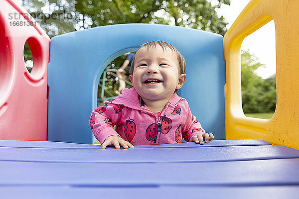 Fröhlich lächelnd Kleinkind Mädchen stehend in bunten Hinterhof Spielset