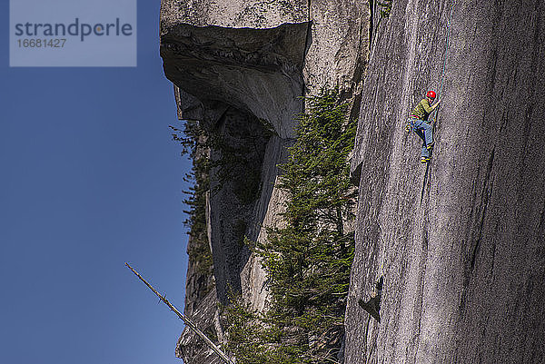 Mann klettert an einer großen  blanken Granitwand in Squamish Chief BC