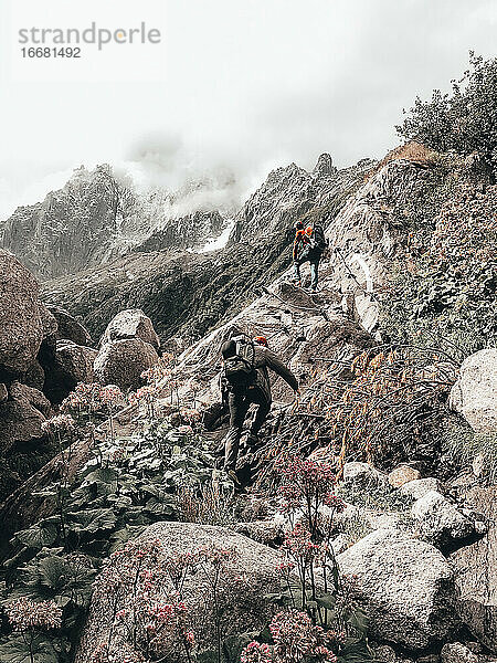 Zwei Kletterer klettern über Felsen auf große Wände zu