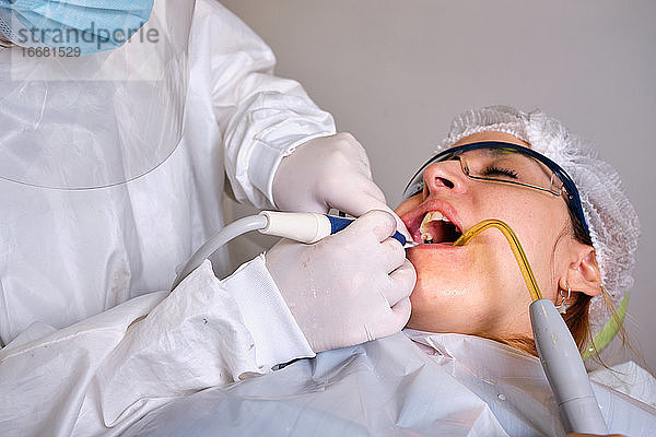 Nahaufnahme einer Zahnärztin  die einem Patienten einen Zahn bohrt