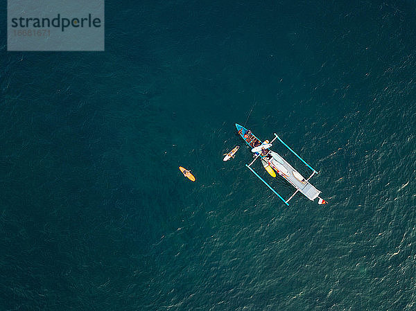Luftaufnahme von Surfern und einem Boot auf dem Meer  Lombok  Indonesien
