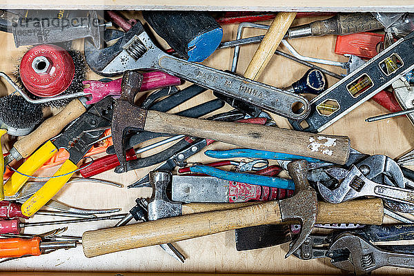 Draufsicht auf verschiedene  gut genutzte Handwerkzeuge im Arbeitsraum