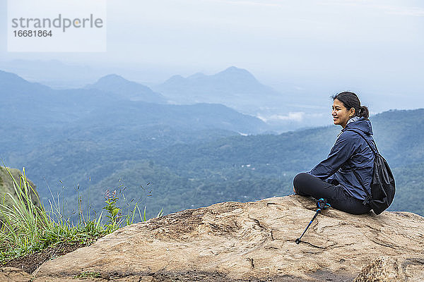 Frau  die sich auf dem Gipfel des Adam's Peak in der Nähe von Ella in Sri Lanka ausruht