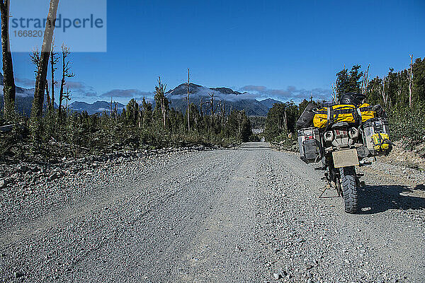 Auf der Carretera Austral auf einer Schotterstraße geparktes Tourenmotorrad