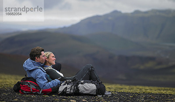 Wanderndes Paar entspannt sich am Berghang in Island