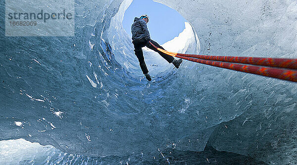 Mann beim Abseilen in eine Gletscherhöhle auf dem Sólheimajökull-Gletscher in Island