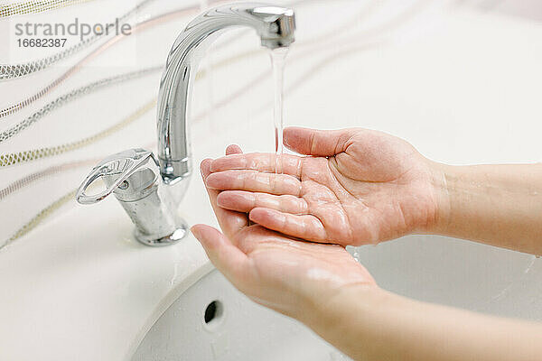 Die Frau wäscht sich die Hände mit der chirurgischen Handwaschmethode.