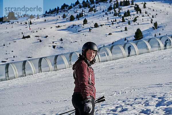 Lächelnde Frau erklimmt die Piste in einem Skifahrerband