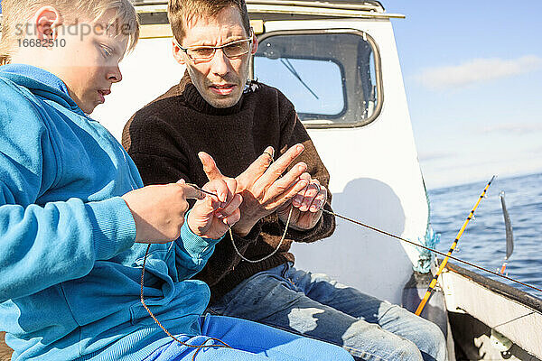 Mann und Jugendlicher fischen zusammen auf einem Boot