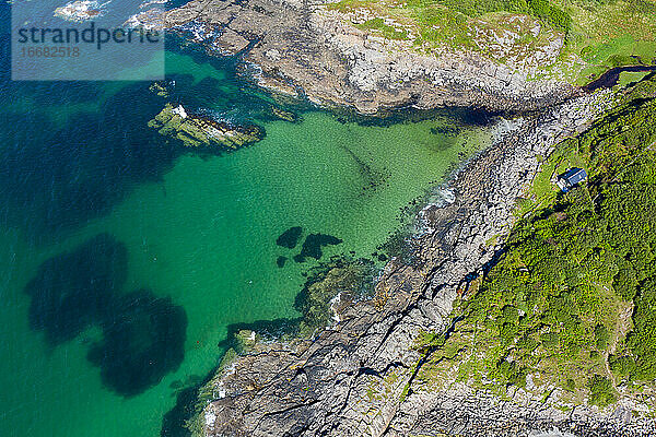 Luftaufnahme der Wellen  die in der Bucht von Portuairk  Schottland  an die Felsen klatschen