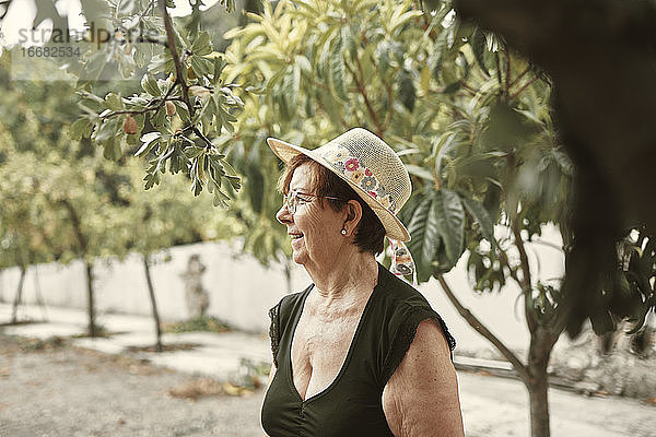 Nahaufnahme einer lächelnden Großmutter in ihrem städtischen Garten