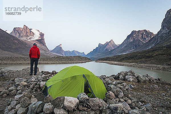 Bergsteiger genießt den Blick auf den Summit Lake von seinem Zeltplatz am Akshayak Pass