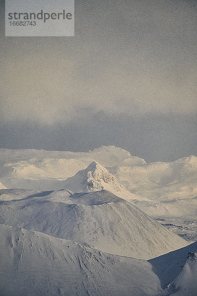 Verschneite Berggipfel an einem nebligen Tag