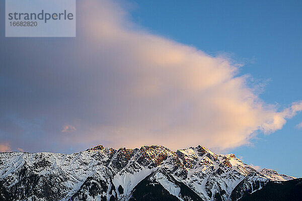 An einem Frühlingstag in den Coast Mountains von British Columbia geht die Sonne über dem Mount Currie unter  der noch mit Schnee bedeckt ist.