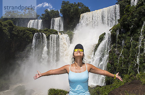 Frau posiert vor den Iguazu-Wasserfällen