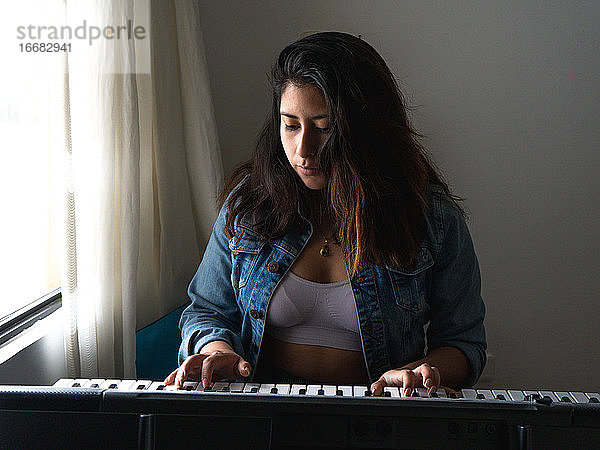 Mädchen spielt Klavier mit Sonnenlicht