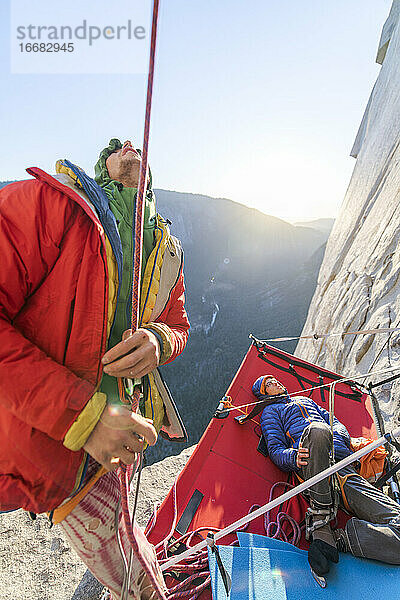 Zwei Männer schauen nach oben  während sie die Nose am El Capitan  Yosemite  besteigen