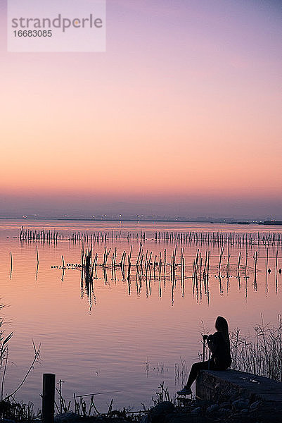 Junges Mädchen genießt den Sonnenuntergang in Valencia Albufera gegen das Licht