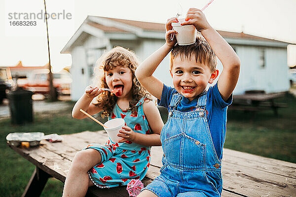 Nahaufnahme von zwei jungen Kindern  die im Sommer Eistüten essen
