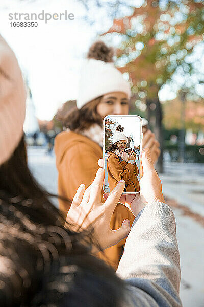 Beste Freunde fotografieren im Park mit ihren Handys