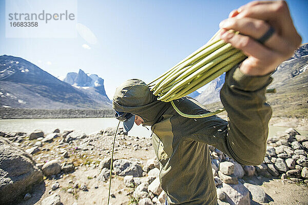 Ein Bergsteiger bereitet das Seil für einen weiteren Klettertag auf Baffin Island vor.