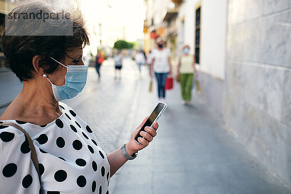 Frau schaute während eines Spaziergangs auf ihr Mobiltelefon