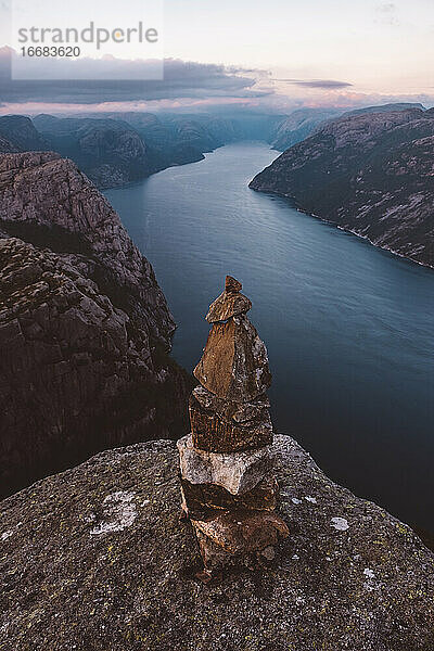 Steinhaufen und Blick auf die norwegischen Fjorde an einem bewölkten Tag