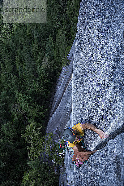 Mann lag mit dem Rücken zu einer breiten Spalte hoch über dem Boden auf Granit Squamish