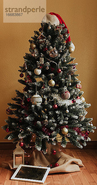 Rahmen und Laterne unter dem geschmückten Weihnachtsbaum in der gemütlichen Stube